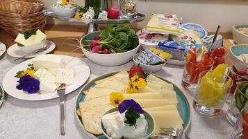 A buffet table with various food items including cheese, radishes, and leafy greens.