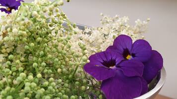 A bowl containing purple flowers and green buds.