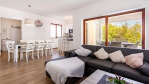 A modern living room with a sofa, coffee table, and dining area. - Gorgeous home in Gostinjac (Gostinjac)