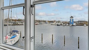 A marina with multiple boats docked, a lighthouse, and buildings in the background. - Gorgeous home in Ebeltoft with WiFi (Ebeltoft)