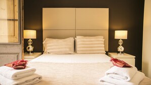 A hotel room with a large bed, two bedside lamps, and neatly folded towels on the bed. - Alcam Molino (Barcelona)