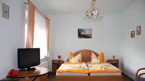 A bedroom with a bed, a desk with a computer, a television, and a chair. - Hotel Parkschänke Zabeltitz (Grossenhain)