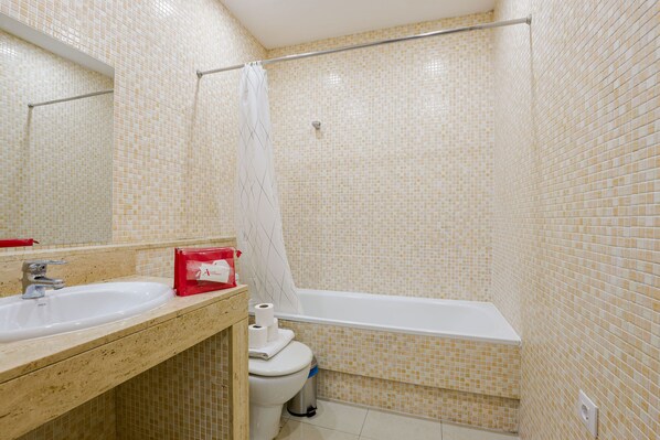 Une salle de bain avec un lavabo, des toilettes et une baignoire.