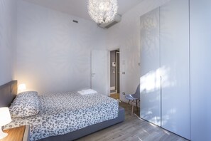 Une chambre à coucher moderne avec un lit, une table de chevet et une chaise.