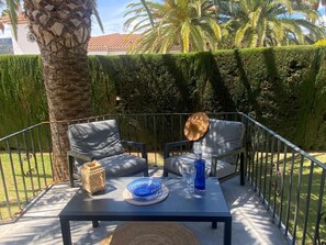 An outdoor seating area with two chairs, a table, and a decorative hat.