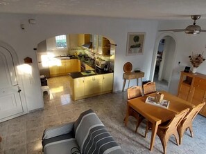 A compact living space with a kitchen, dining area, and a sofa. - Charming detached house with private pool in Miami Playa (Mont-roig del Camp)