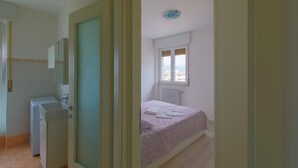 Un dormitorio con cama, radiador y ventana.