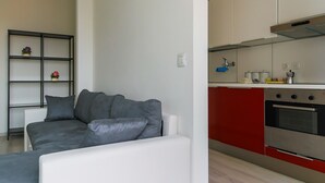 Una cocina moderna con gabinetes rojos y un horno de acero inoxidable.