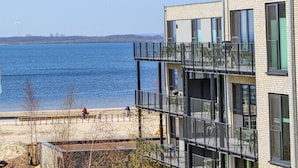 A modern building with multiple balconies overlooking a body of water. - Pet friendly apartment in Lembruch/Dümmer See with WiFi (Lembruch/Dümmer See)