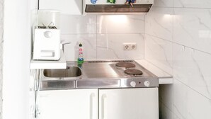 Une cuisine compacte dotée d’une cuisinière intégrée, d’un évier et d’un petit plan de travail.