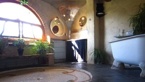 A bathroom with a bathtub, a mosaic floor, and potted plants. - Vacation home, great views, billiards, large spaces (Manses)