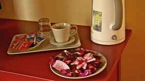 Una bandeja con una taza, una tetera y un plato de flores secas.