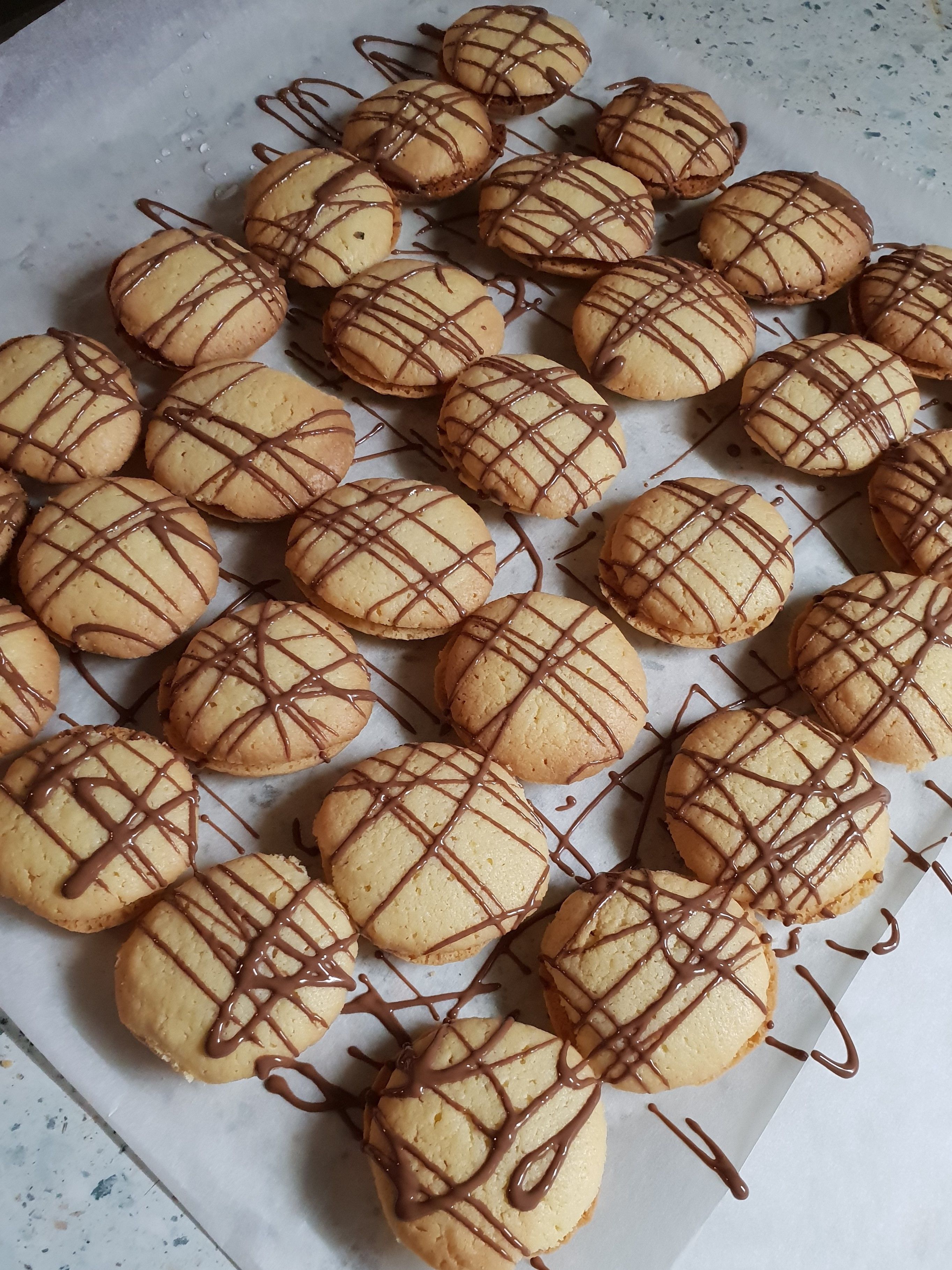 Una bandeja de galletas redondas con glaseado de chocolate.
