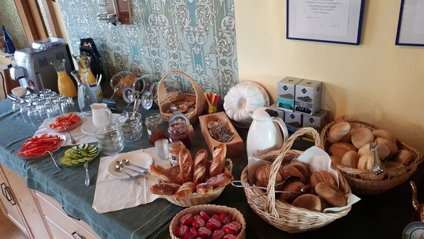 A buffet table with various food items, including bread, pastries, and fruits. - Gasthof Bauer (Elsendorf)