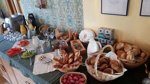 A buffet table with various food items, including bread, pastries, and fruits. - Gasthof Bauer (Elsendorf)