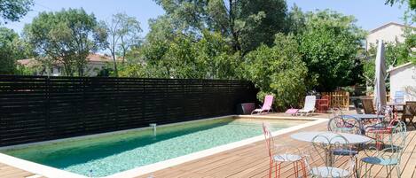Una piscina al aire libre de temporada, sombrillas