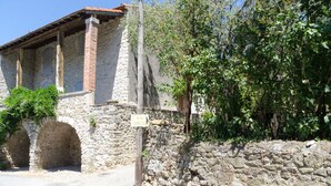 A stone building with arched doorways and a signpost. - MAS ABICOU - chambres d'hôtes (Vezenobres)