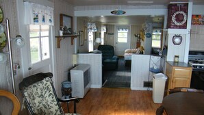 A compact living space with a dining area, a kitchenette, and a seating area with a chair and a sofa.