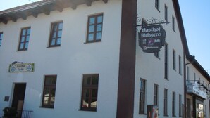 A building with multiple windows and a sign for "Gasthof Metzgerei" indicating a restaurant or inn.