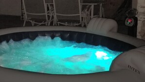 Un jacuzzi intérieur avec un plafond en bois et un escalier en arrière-plan.