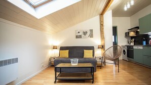 Une pièce confortable avec un lit, une petite table, une chaise et un coin cuisine.