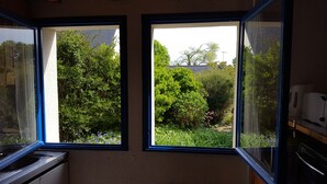 Eine Küche mit zwei Fenstern, die auf einen Garten blicken.