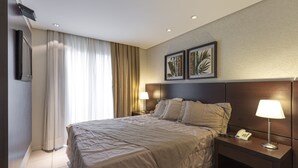 A hotel room with a bed, nightstands, a telephone, and two wall-mounted lamps. - Hotel Plaza Norte (Joinville)
