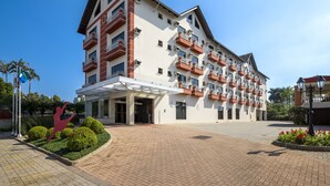 A multi-story hotel with a white facade, red accents, and balconies. - Hotel Plaza Norte (Joinville)