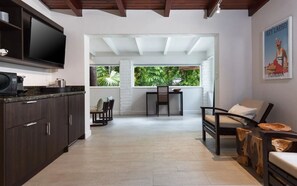Una cocina moderna con armarios oscuros, un televisor de pantalla plana y un comedor con mesa y sillas.