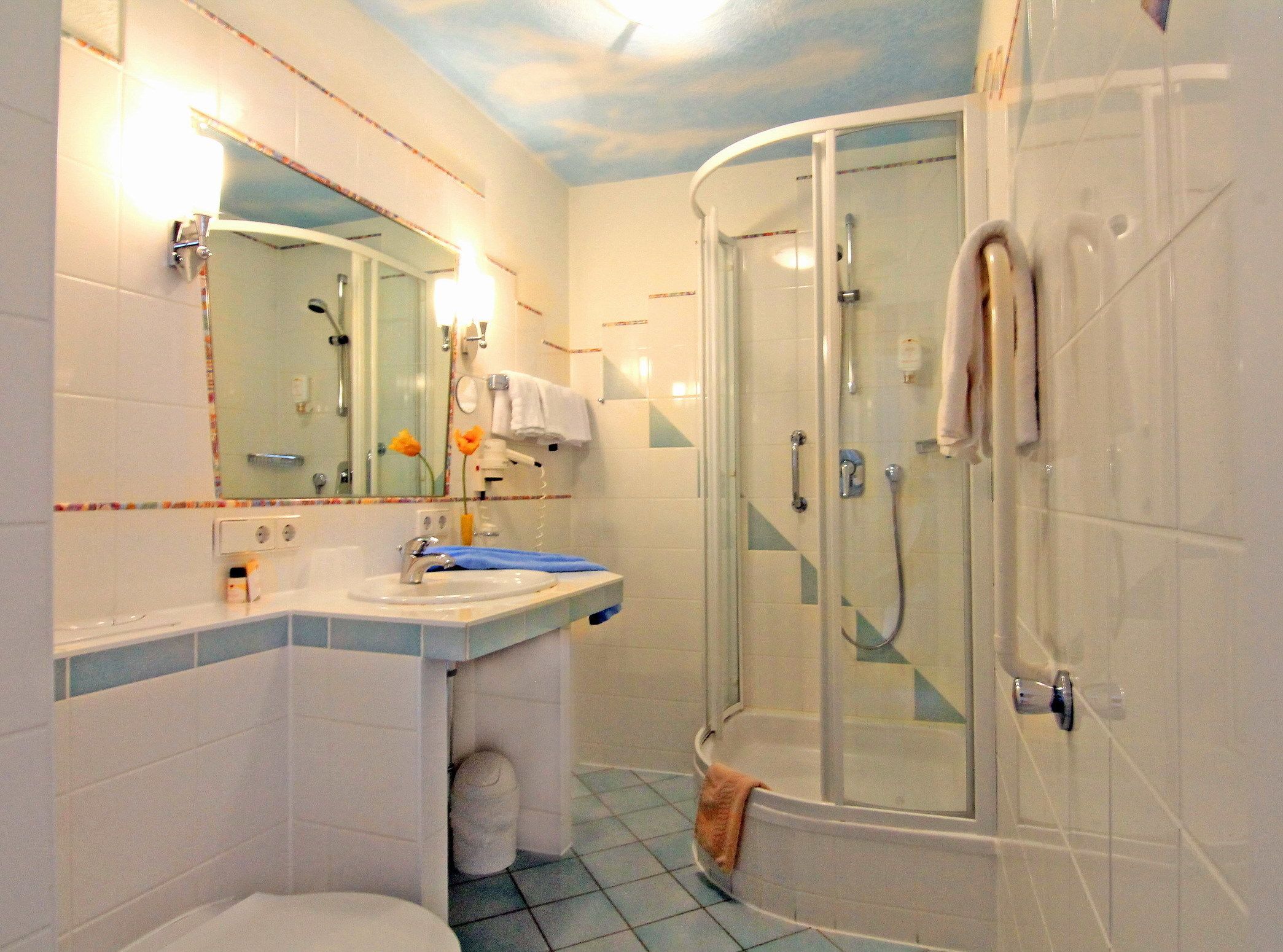 Ein Badezimmer mit Dusche, Waschbecken und Toilette.