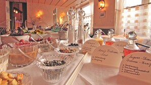 A buffet table with various food items and condiments.