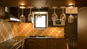 A modern kitchen with a checkered tile backsplash, wooden cabinets, and a central island with a sink.