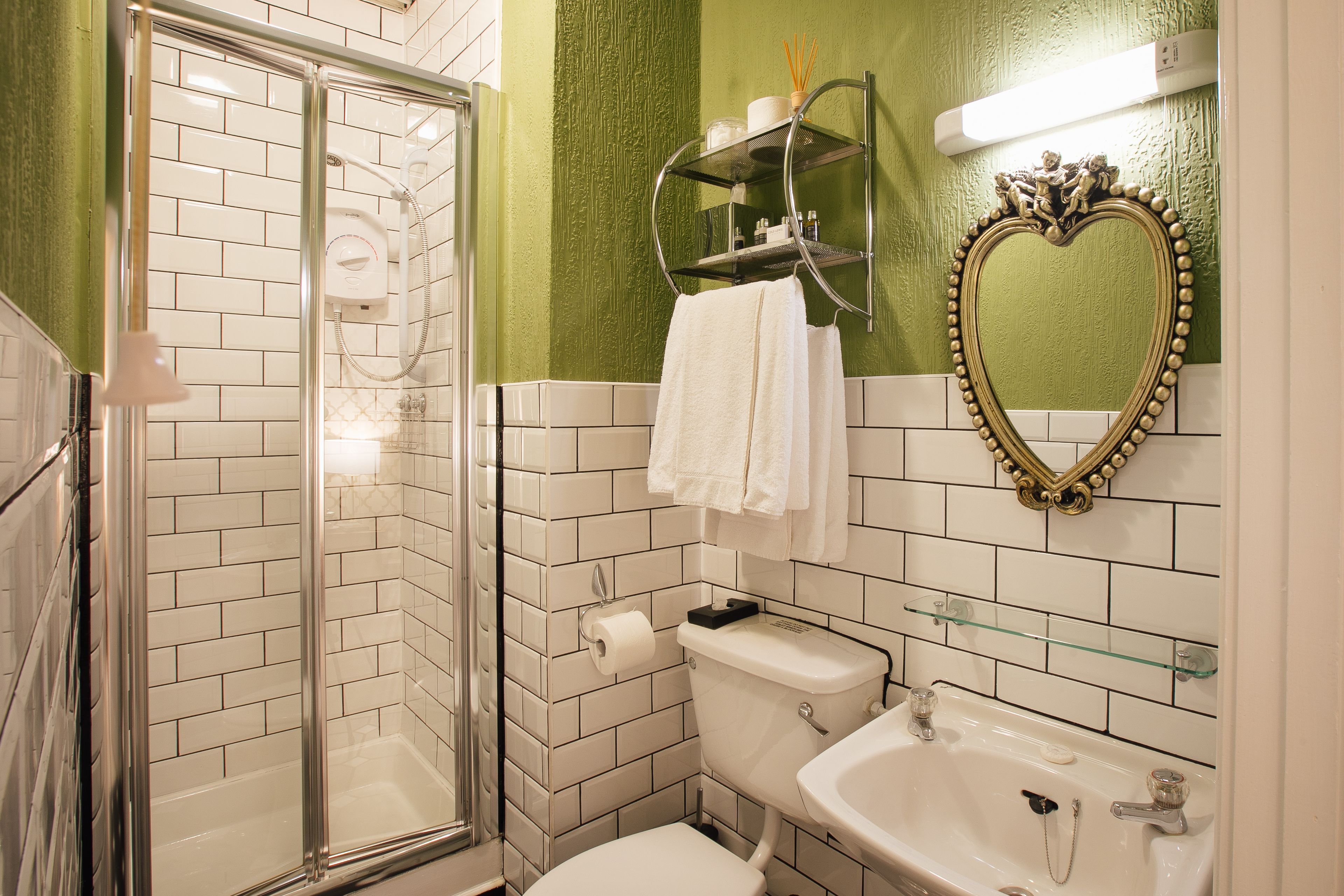 Une salle de bain avec une douche à parois de verre, des toilettes, un lavabo et un meuble-lavabo avec un miroir.