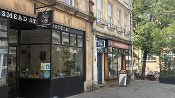A street with shops, including a coffee shop and a carpet store.
