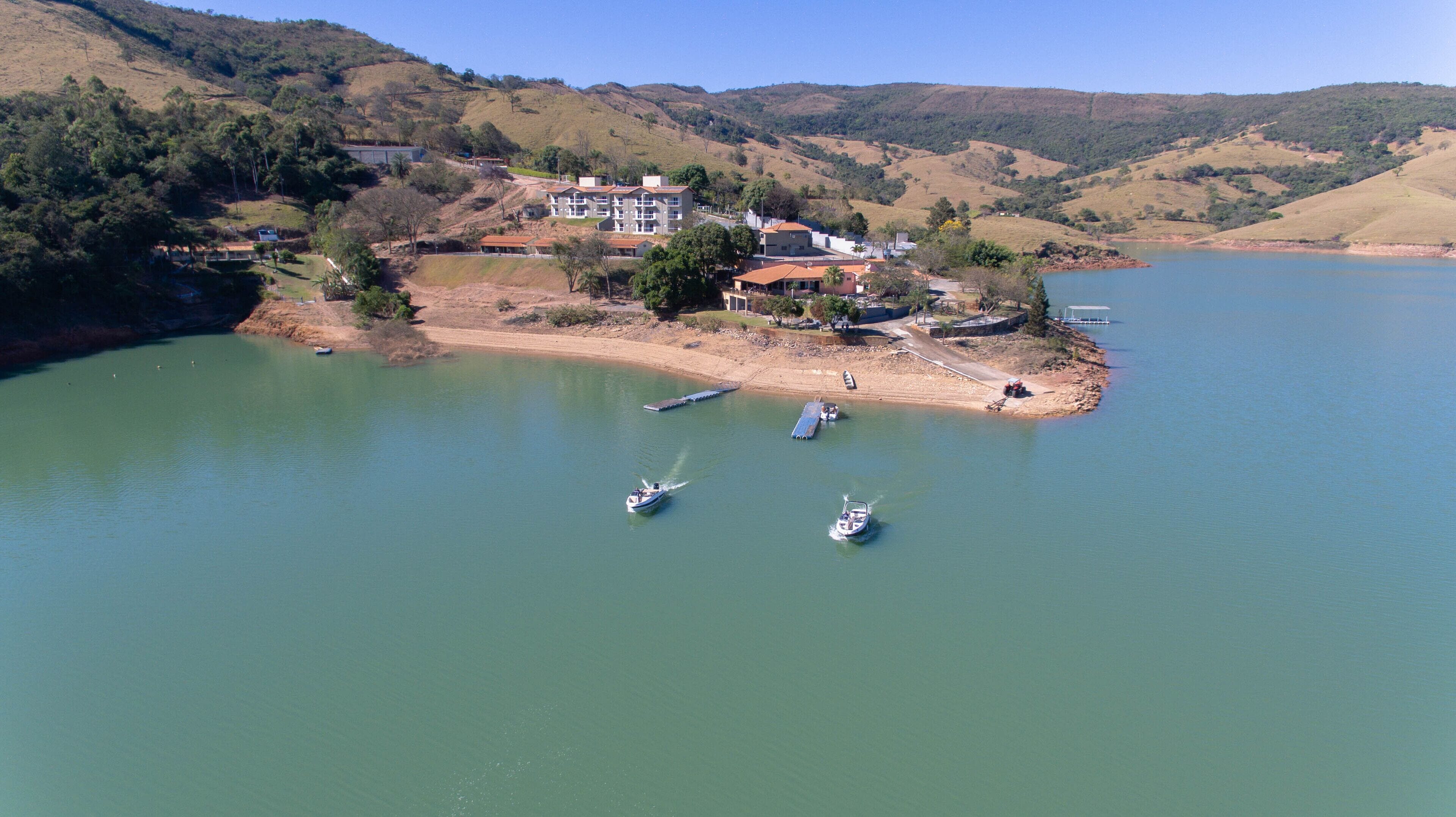 Propiedad frente al lago con una casa grande, un muelle y barcos.