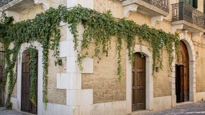 A building with a stone facade, arched doorways, and a balcony with wrought iron railings. - Le Foglie di Acanto (Lucera)