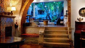 A cozy interior with a staircase leading to a balcony, a dining area with a table and chairs, and a wall-mounted clock. - Le Foglie di Acanto (Lucera)