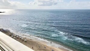 A beach with a clear view of the ocean, a sandy shore, and a few umbrellas. - Breathtaking Ocean View (Salvador)