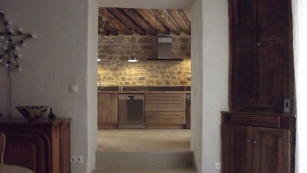 Eine Küche mit Steinwand, Holzschränken und einem Geschirrspüler.