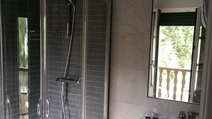 A modern bathroom with a glass-enclosed shower, a sink, and a mirror. - Hotel Restaurante Aldama (Amurrio)