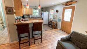A kitchen with wooden cabinets, a bar area, and a refrigerator.