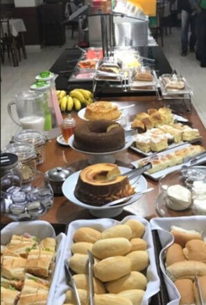 A buffet table with various food items including cakes, sandwiches, and pastries. - Hotel Garrafão Boituva (Boituva)