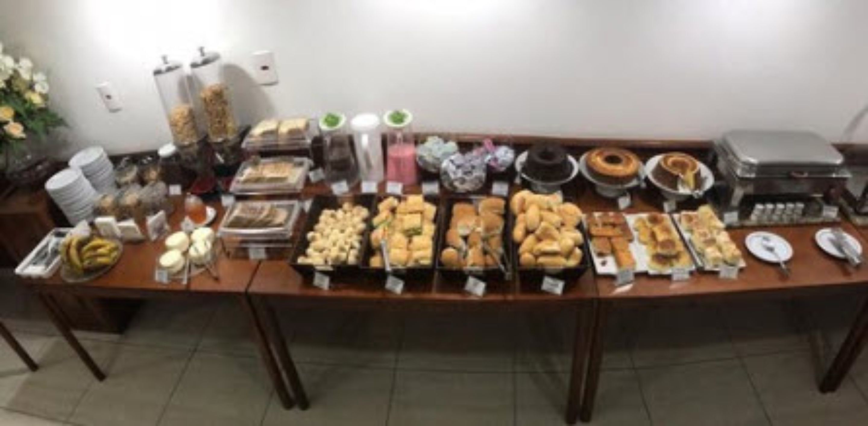A buffet table with various food items and condiments.
