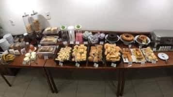 A buffet table with various food items and condiments.
