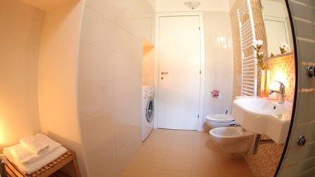 Un baño pequeño con inodoro, lavamanos y espejo.