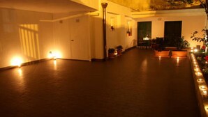 A spacious room with a wooden floor, a high ceiling, and a long row of candles along the wall. - Holiday home L'Alloro with private parking - MATERA (Matera)