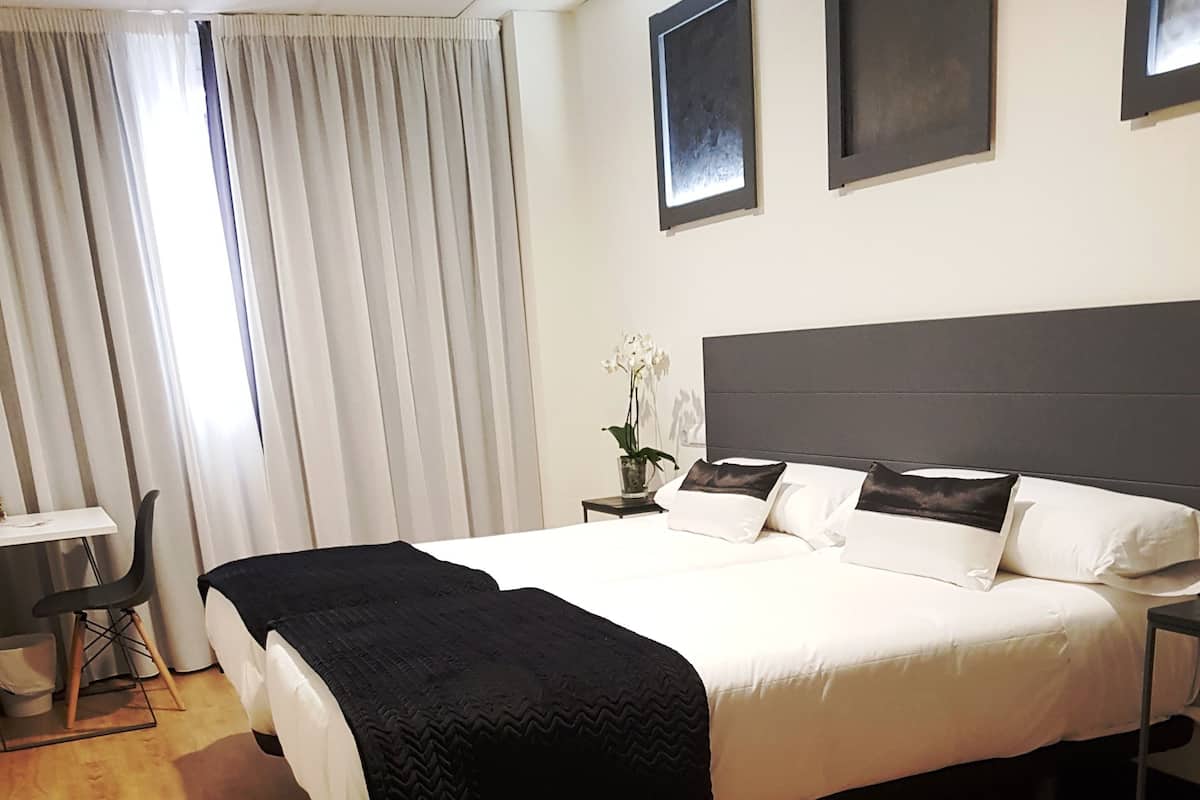Une chambre d’hôtel avec un grand lit, une table de chevet, une chaise et un bureau.