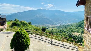 A stone building with a balcony overlooking a mountainous landscape. - House Forn for 6 people (Sort)