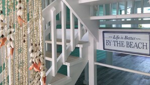 Un escalier sur lequel est affiché un panneau indiquant : « La vie est plus belle au bord de la mer. »