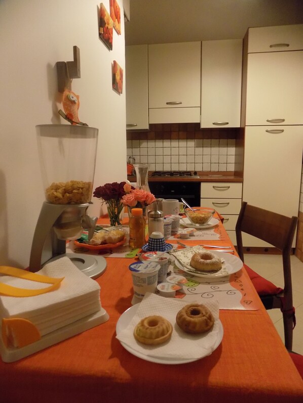 A dining table set with plates, bowls, and a vase of flowers.